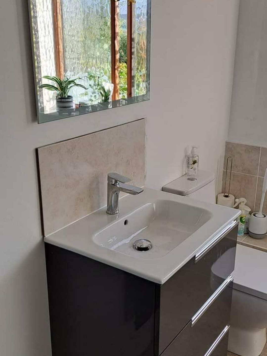 Bathroom installation with square basin and fitted storage cabinet